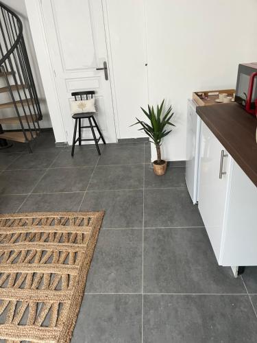 a kitchen with white cabinets and a tile floor at Tiny house 4 min drive to Cdg airport in Roissy-en-France