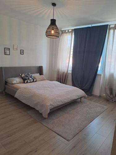 een slaapkamer met een bed en een kroonluchter bij Enjoy traveling in Tuzla