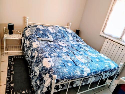 une chambre avec un lit avec une couverture bleue dans l'établissement maison piscine privée Robion Luberon idéal famille, à Robion