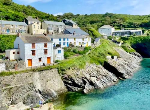 a village on the shore of a body of water at Just Opened. Romantic Clifftop Retreat in Portloe