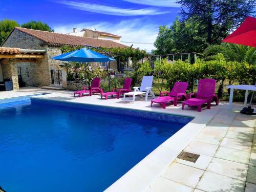 einen Pool mit lila Stühlen und einem Sonnenschirm in der Unterkunft maison piscine privée Robion Luberon idéal famille in Robion en Luberon