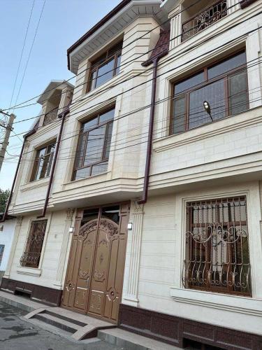 un edificio bianco con una porta con un orso sopra di CRYSTAL GUEST HOUSE a Samarkand