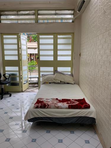 een slaapkamer met een bed in een kamer met ramen bij Sky Happy in Ho Chi Minh-stad