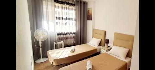 トレビエハにあるApartamento Torreviejaの小さな客室で、ベッド2台、ファンが備わります。