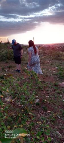 two people are walking in a field with a spear at Orboma Masai homestay in Sekenani