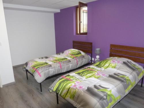 two beds in a room with purple walls at Logement spacieux rez-de-chaussée, jardin, stationnement devant, à 5 minutes à pied du centre de Sarlat in Sarlat-la-Canéda