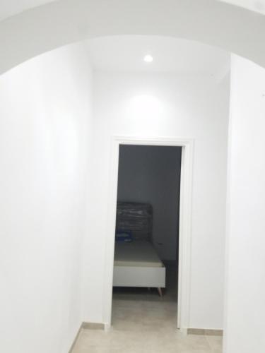 a room with a bed in a white room at Joli Villa à Sahloul in Sousse