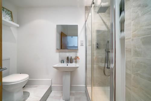 a bathroom with a shower and a sink and a toilet at Modern 1 Bedroom City Penthouse Apartment in London