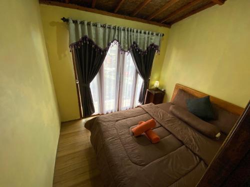 a bedroom with a bed and a large window at D'Yoga Bamboo House in Kintamani