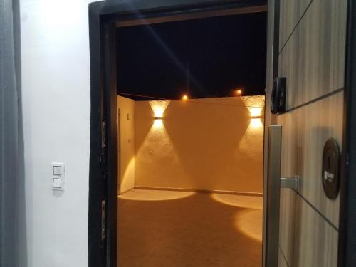 an open door with lights on a balcony at night at Joli Villa à Sahloul in Sousse