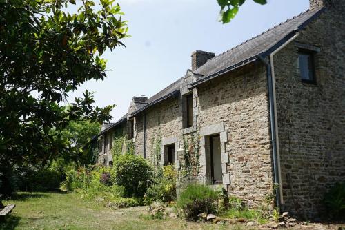 an old stone house with a garden in front of it at Gîte à la campagne, 30 min des plages du Morbihan in Pluvigner