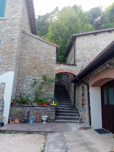 a stone building with stairs and a door and a building at B&B BORGORI' in Rivola