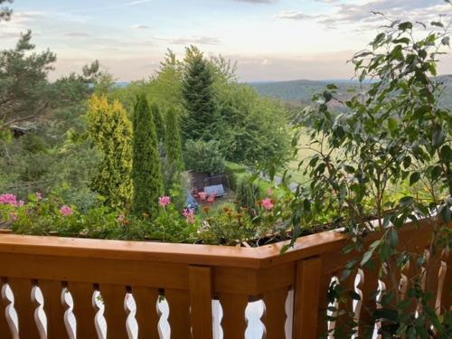 a wooden balcony with a garden of flowers at Ferienwohnung „Am Bankzeitweg“ in Saalfeld