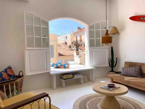 un salon avec une grande fenêtre et un canapé dans l'établissement Maison Meynadier, à Cannes