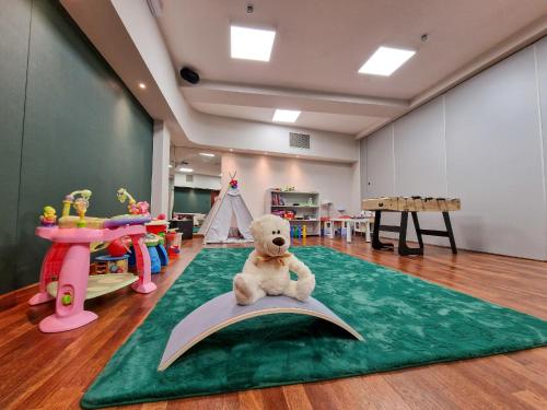 a teddy bear sitting on a book in a classroom at Hotel ARA - Dancing Club Restauracja ARA in Jastrzębia Góra