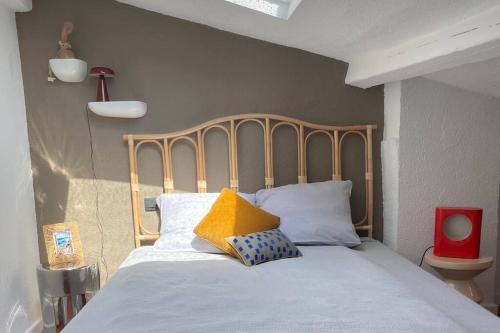 un lit avec une tête de lit en bois dans une chambre dans l'établissement Maison Meynadier, à Cannes