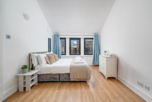um quarto branco com uma cama e uma janela em Modern 1 Bedroom City Penthouse Apartment em Londres