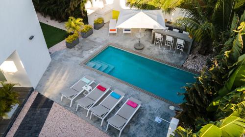 an overhead view of a swimming pool with chairs and a table at Tropical Eden Villa in Jan Thiel