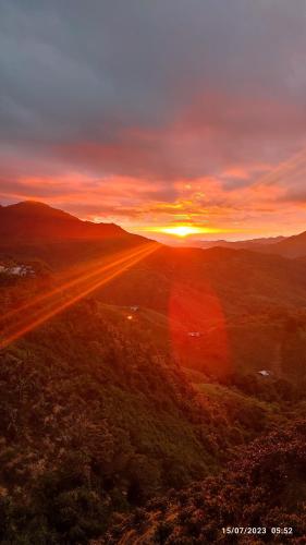 a sunset over a field with the sun setting in the distance at Finca Hotel Betel in San Carlos