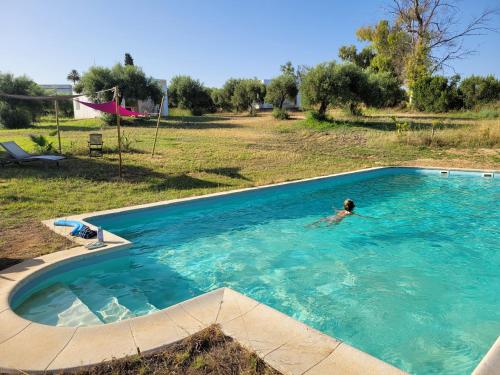 a person swimming in a large swimming pool at bungalow entre mer et montagne in Arcos de la Frontera