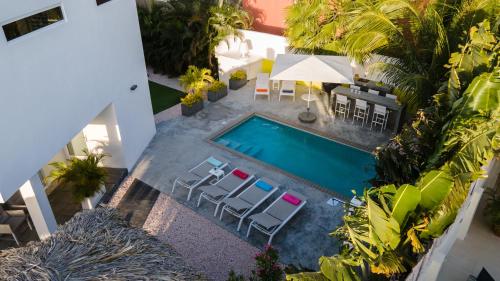 an overhead view of a swimming pool with chairs and tables at Tropical Eden Villa in Jan Thiel