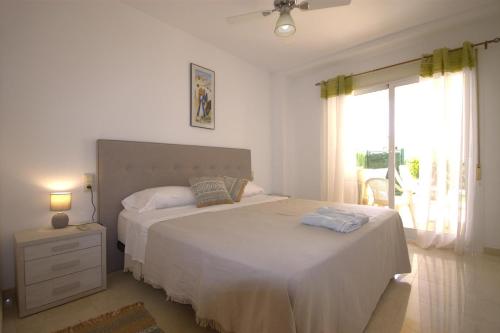 ein Schlafzimmer mit großem Bett und Fenster in der Unterkunft Golden in Jávea