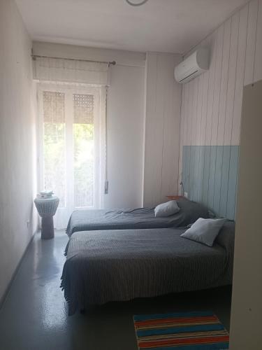 um quarto com 2 camas e uma janela em appartamento vale em Viareggio