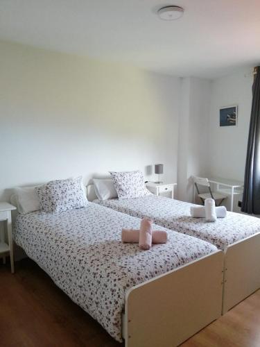 a bedroom with a large bed with two towels on it at Rua as Neves in Malpica
