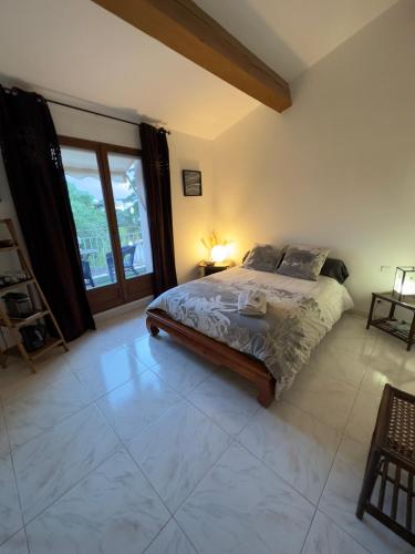 une chambre avec un lit et une grande fenêtre dans l'établissement Chambre privée avec salle d’eau et terrasse au calme, au Cannet