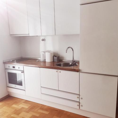 a kitchen with white cabinets and a sink at Central apartment in Prilep in Prilep