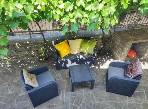 un patio con 2 sillas y una mesa con almohadas en Apartment Fragola, en Ankaran