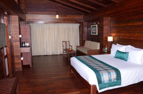 a bedroom with a bed and a couch in a room at GReaT Trails Kodaikanal by GRT Hotels in Kodaikānāl