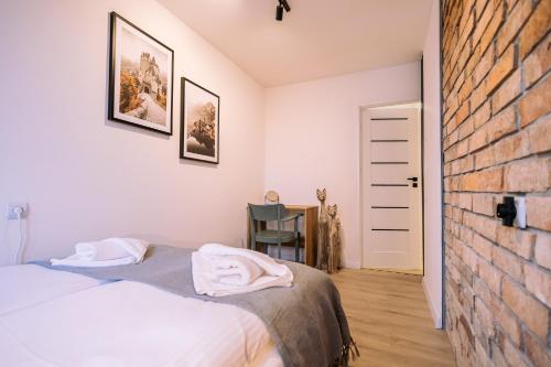 a bedroom with a bed and a brick wall at Apartament Miejski Chill in Toruń