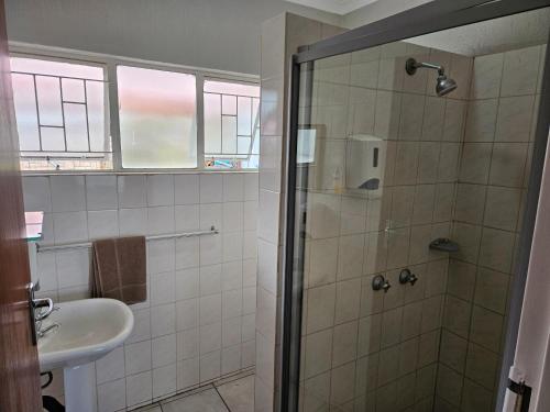 a bathroom with a shower and a sink at Pietersburg Lodge in Polokwane