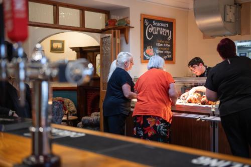 a group of people standing at a counter preparing food at The Seacourt in Bridlington