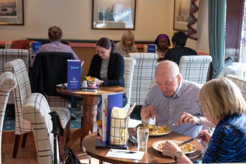 a man and a woman sitting at a table eating food at The Seacourt in Bridlington