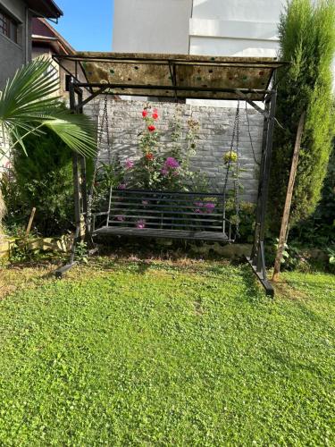a swing in a garden with some flowers at The Local B&B in Srinagar