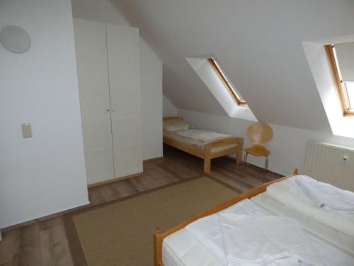 een zolderkamer met een bed en een stoel bij Ferienwohnung "Parkresidenz Concordia" - Wohnung 9 in Ostseebad Sellin