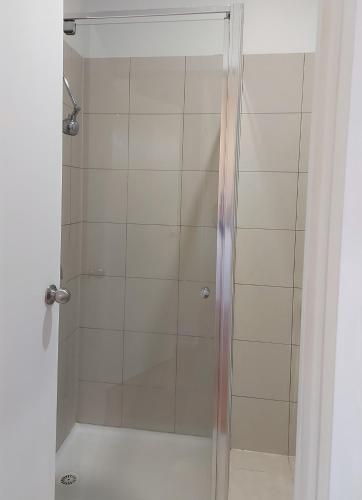 メルボルンにあるMaruve Guesthouse 12 min from Melb airportの浴室のガラス扉付きシャワー