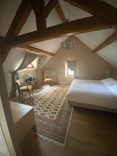 a bedroom with a bed and a chair and a table at Château de Bouesse en Berry in Bouesse
