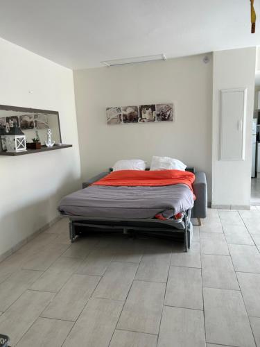 a bedroom with a bed and a tile floor at Les Gîtes de la Colo in Ravenoville