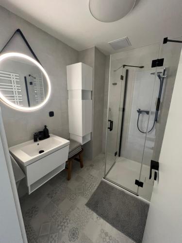 a white bathroom with a sink and a shower at Kasperky 14 in Kašperské Hory