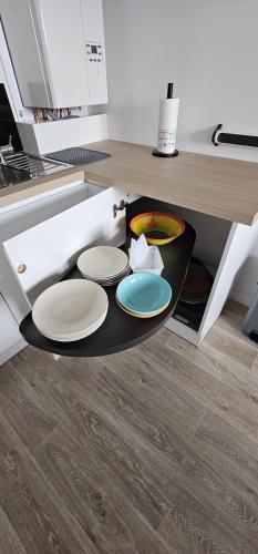 a kitchen with a table with plates on it at Location T2 neuf ecoquartier portes du Bassin D'ARCACHON in Biganos