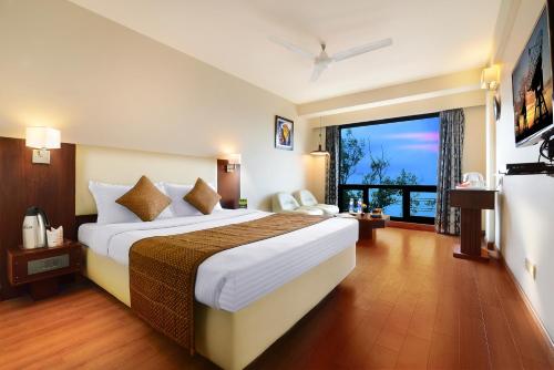 a hotel room with a large bed and a large window at Honeymoon Inn Mussoorie in Mussoorie