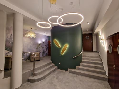 a staircase with a green wall with a gold feather on it at Hotel ARA - Dancing Club Restauracja ARA in Jastrzębia Góra