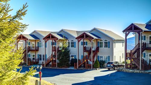 a large apartment building with staircases in a parking lot at Klonteska Condominiums By VCI Real Estate Services in Beech Mountain