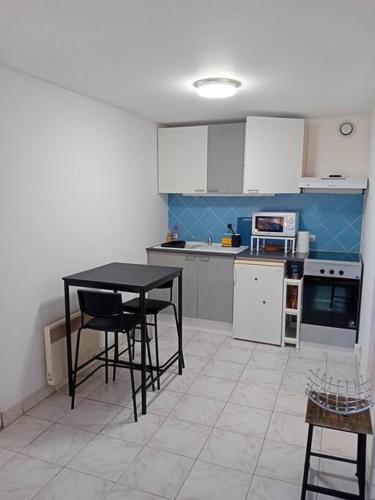 une cuisine avec une table noire et des chaises dans l'établissement La petite maison à la campagne / our little house, à La Chapelle-Launay