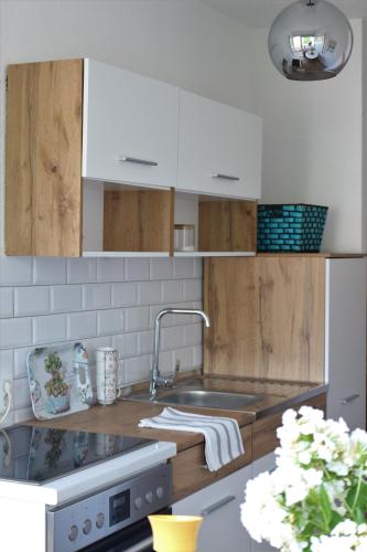 a kitchen with white cabinets and a sink at Blue Apartment in Bihać