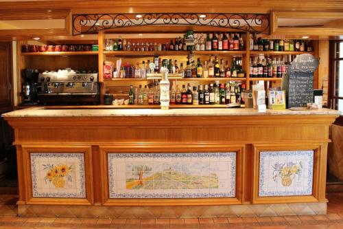 a bar in a restaurant with a lot of alcohol at Logis Grand Hotel Bain in Comps-sur-Artuby