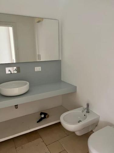 a bathroom with a sink and a toilet and a mirror at Palazzo dei Gigli Puglia - house with heatable rooftop-Pool in Ugento